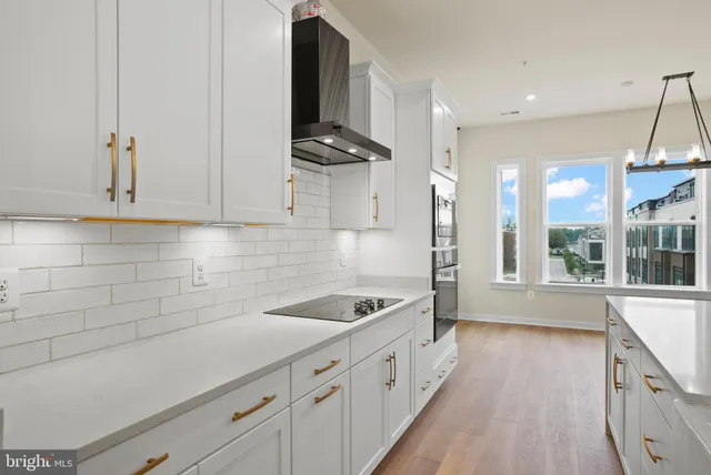 a kitchen with granite countertop a sink a stove and cabinets