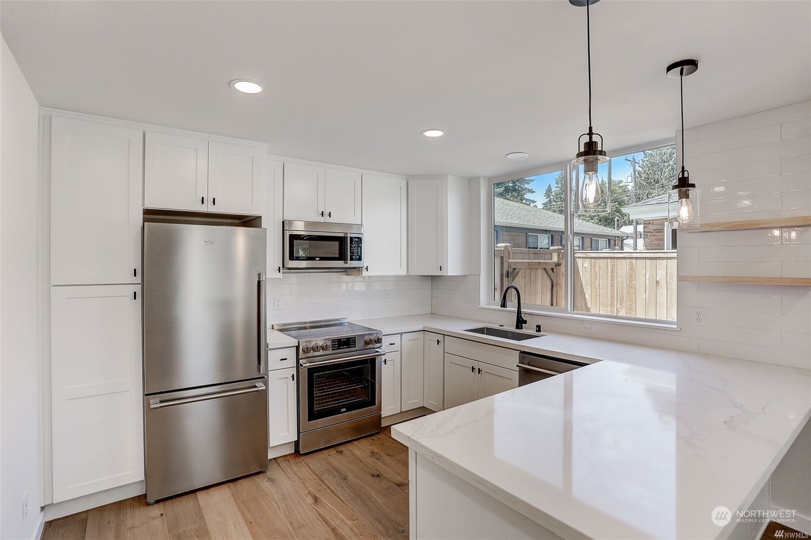 3221 Northeast 86th Street Seattle, WA 98115 - Photo 8 of 22 a kitchen with stainless steel appliances granite countertop a refrigerator a stove a sink and a refrigerator