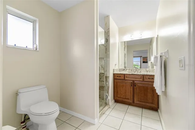 a bathroom with a granite countertop sink toilet and mirror