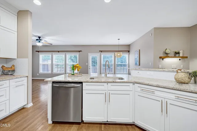 a kitchen with granite countertop white cabinets and window
