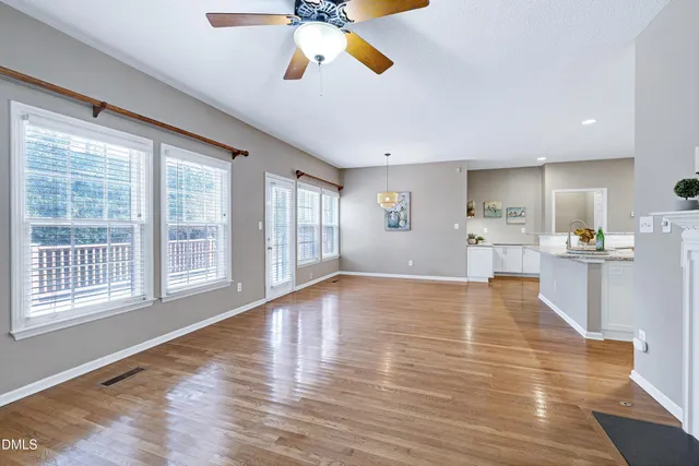 a view of an empty room with a window and wooden floor