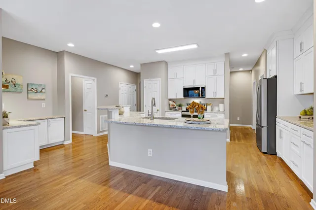 a kitchen with stainless steel appliances granite countertop a refrigerator a sink and a stove