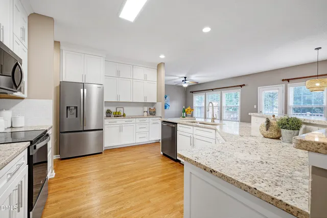 a kitchen with granite countertop a refrigerator stove and sink