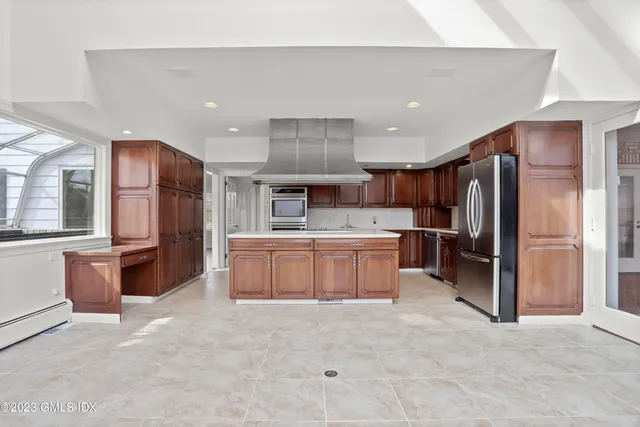 a large kitchen with a large counter top stainless steel appliances and cabinets