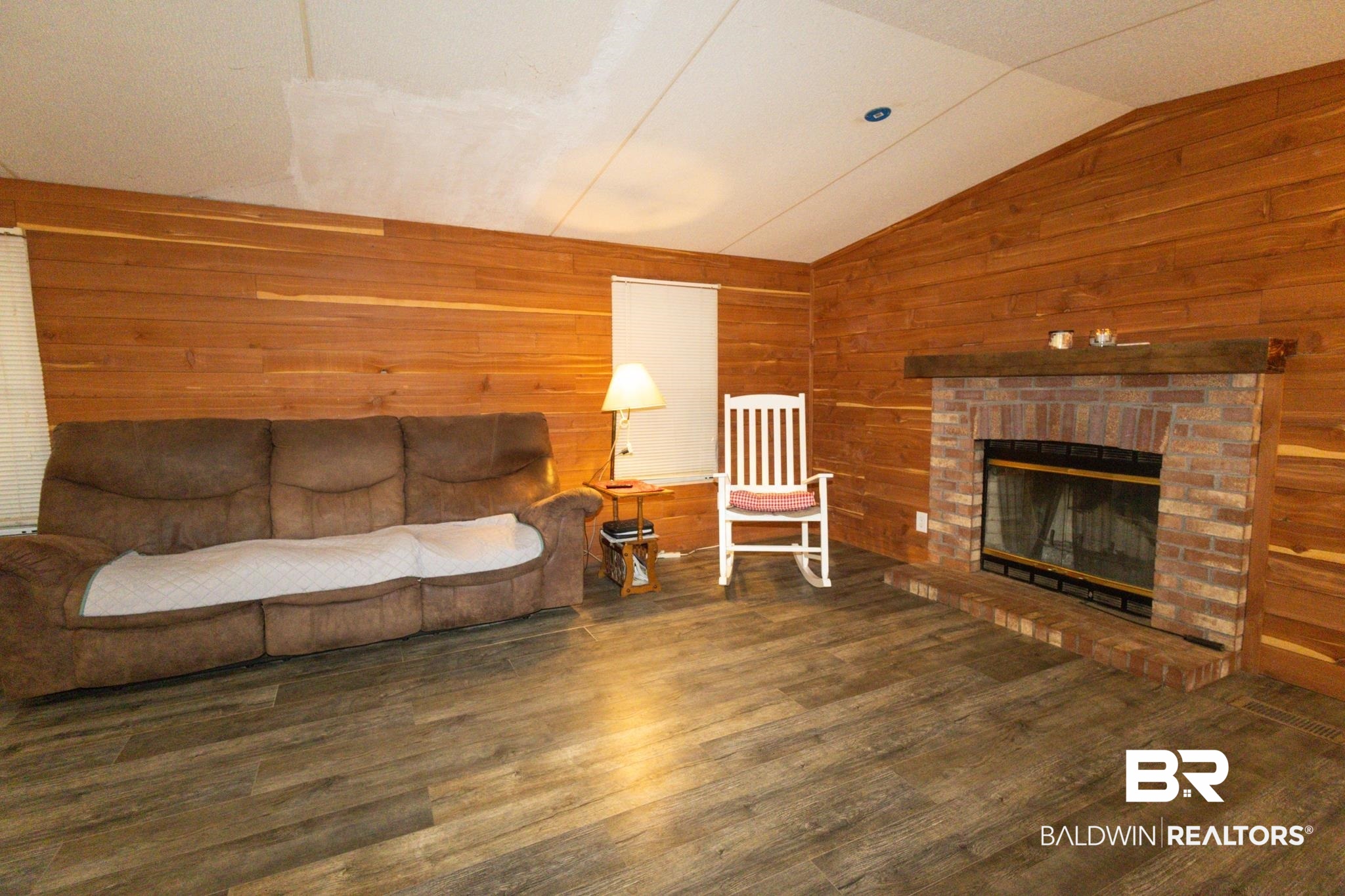 588 A D Clark Road Castleberry, AL 36432 - Photo 5 of 17 Living room with wood walls, lofted ceiling, a fireplace, and dark wood-style floors