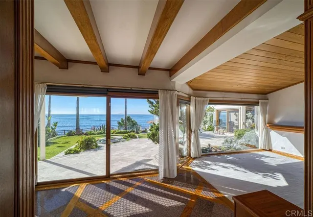a living room with a floor to ceiling window and wooden floor