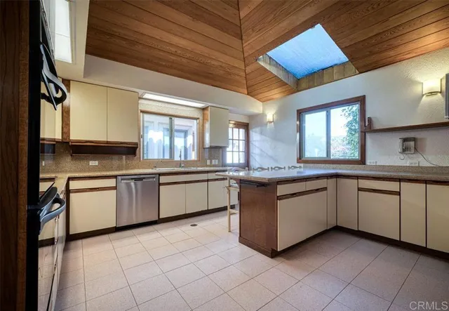 a kitchen with granite countertop a sink window and cabinets