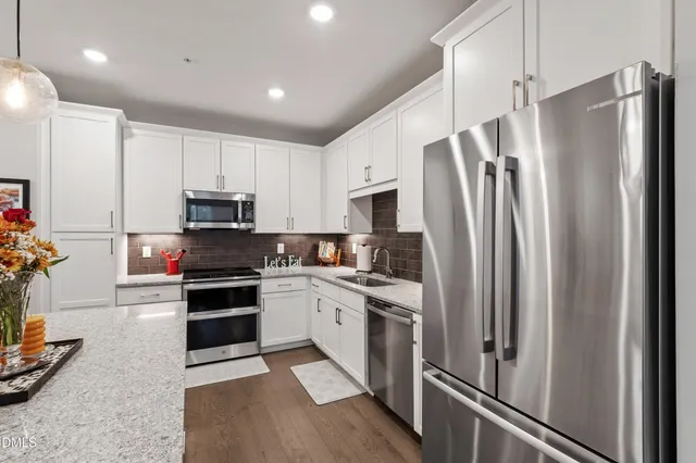 a kitchen with a refrigerator a stove and cabinets