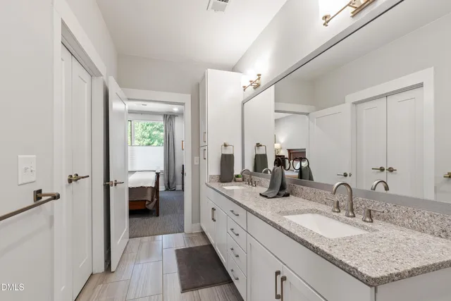 a bedroom with a bed and a flat tv screen on dresser