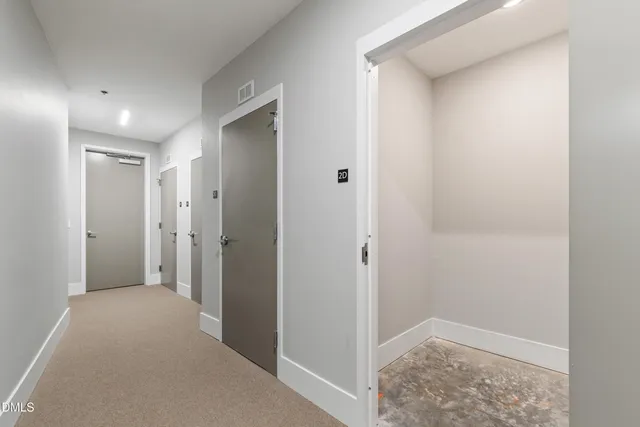 a view of hallway with closet and wooden floor