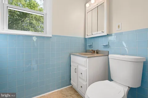 a bathroom with a toilet sink and mirror
