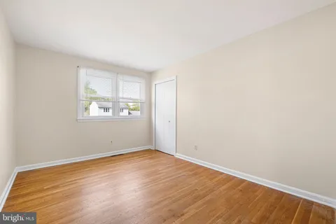an empty room with wooden floor and window
