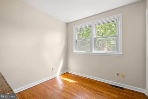 a view of a room with wooden floor and a window