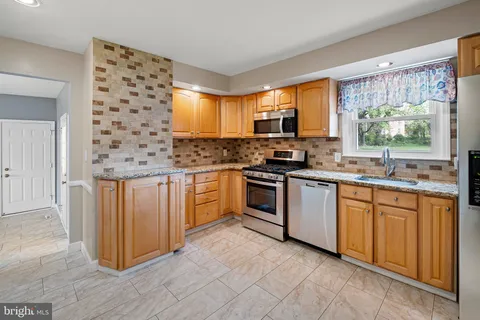 a kitchen with stainless steel appliances a stove sink and microwave