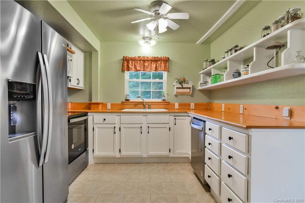 6295 Crabtree Road Clyde, NC 28721 - Photo 25 of 37 a kitchen with cabinets stainless steel appliances and a window