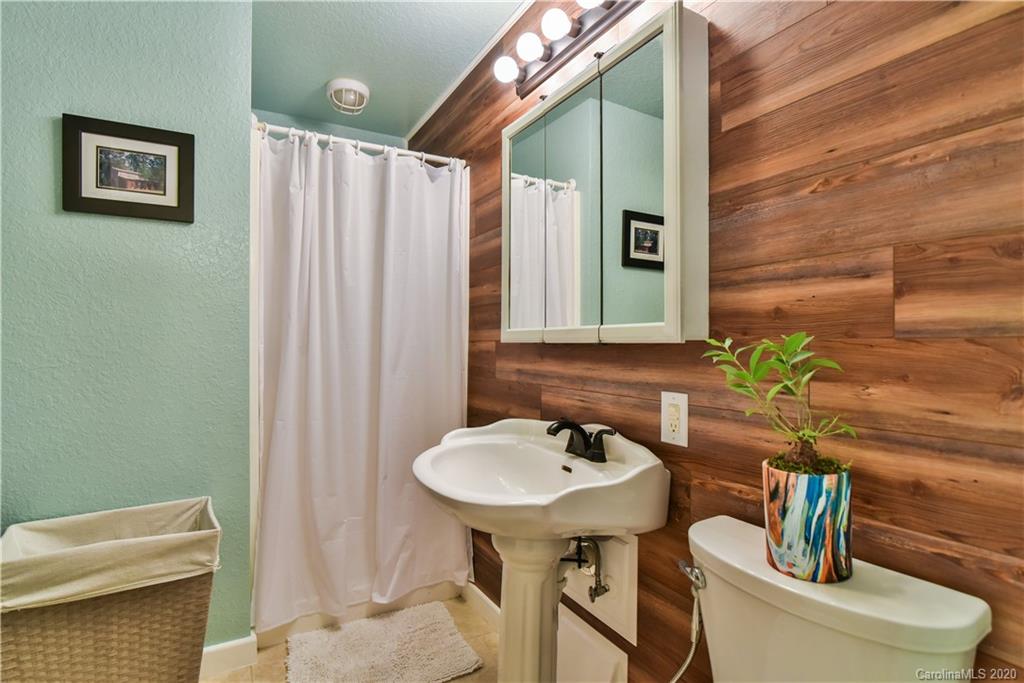 6295 Crabtree Road Clyde, NC 28721 - Photo 28 of 37 a bathroom with a toilet sink and mirror