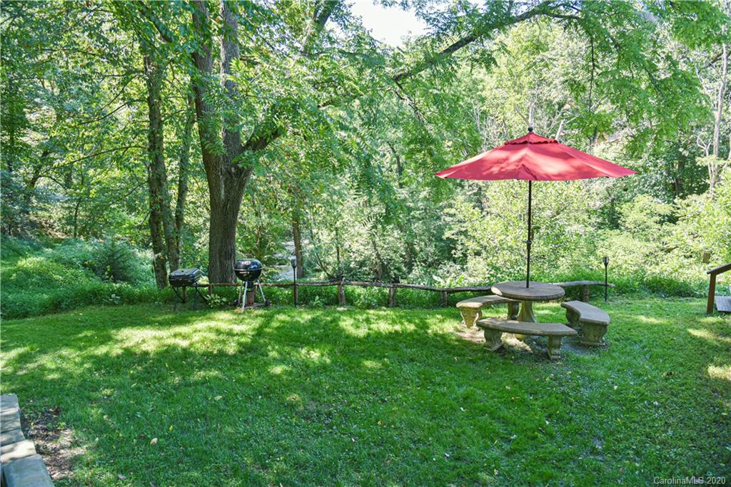 6295 Crabtree Road Clyde, NC 28721 - Photo 4 of 37 a view of a garden with a bench and plants
