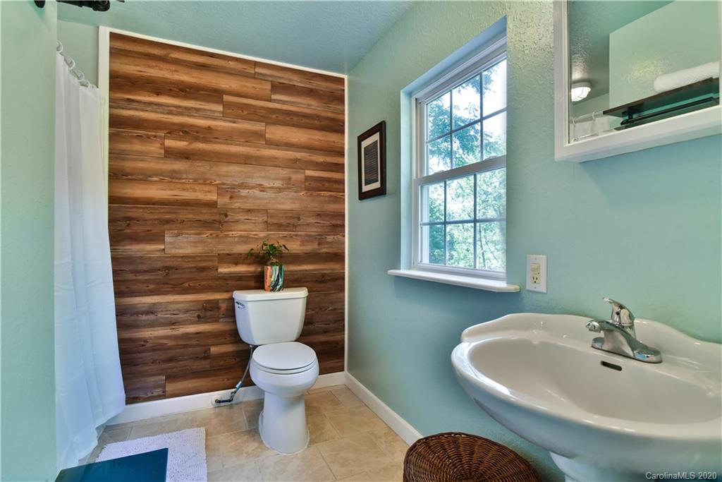 6295 Crabtree Road Clyde, NC 28721 - Photo 32 of 37 a bathroom with a sink a toilet and a window