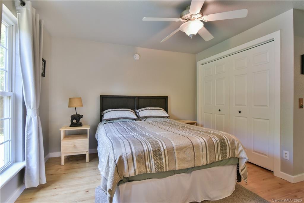 6295 Crabtree Road Clyde, NC 28721 - Photo 33 of 37 a bedroom with a bed and a chandelier