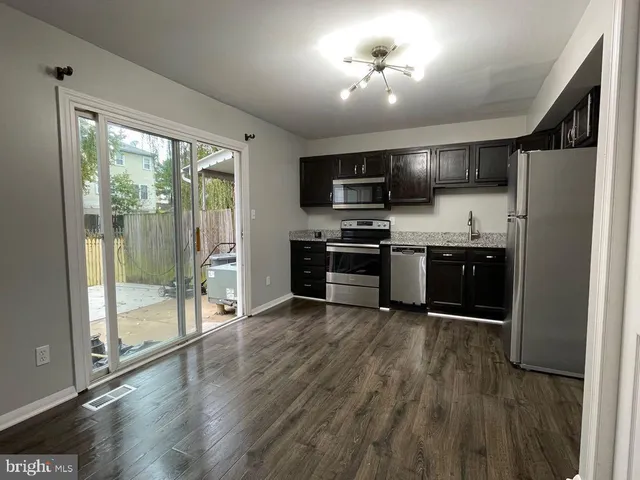 a kitchen with stainless steel appliances a stove top oven a sink and a refrigerator