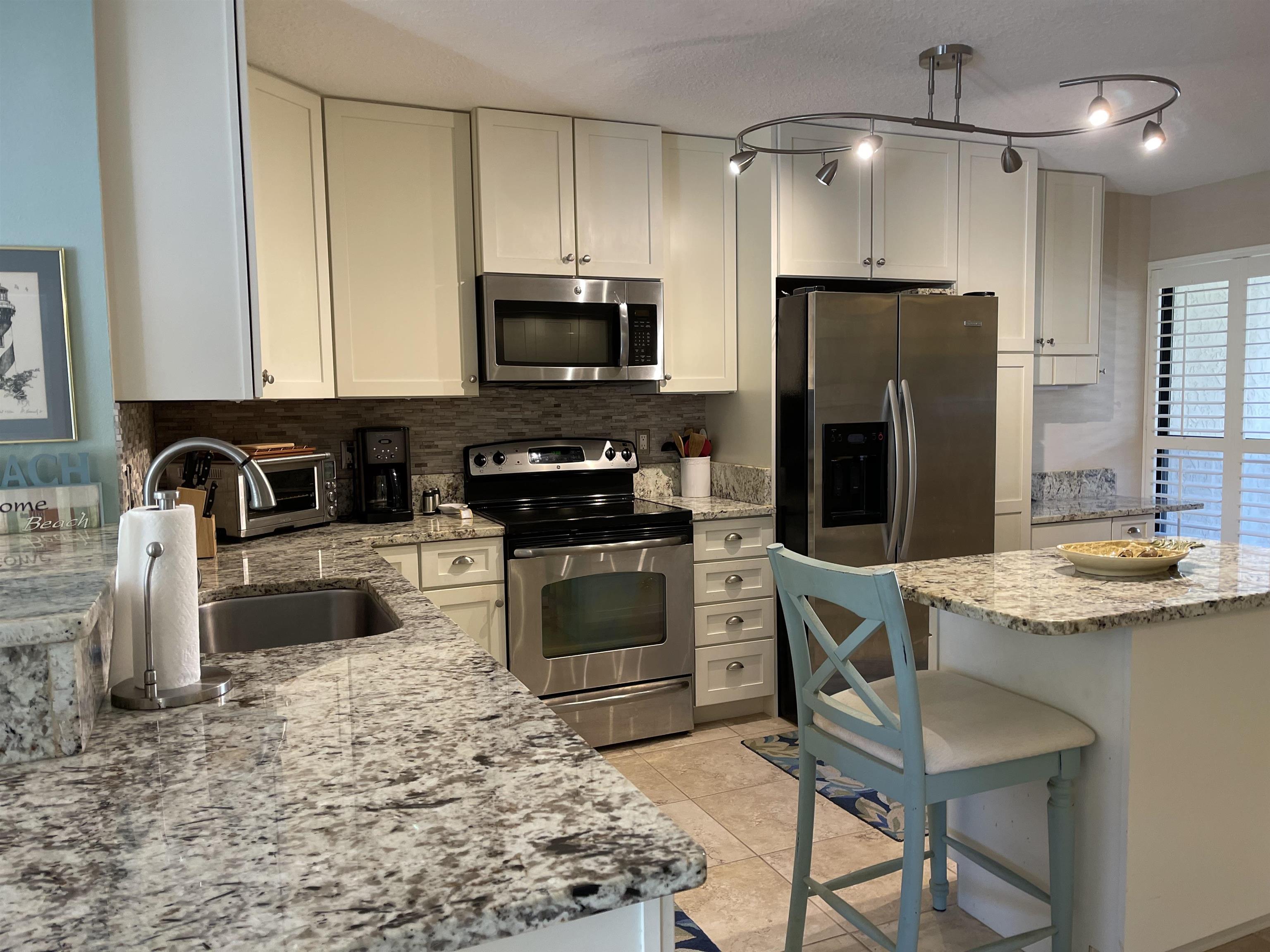 213 Pacifica Vista Way St. Augustine, FL 32080 - Photo 13 of 29 a kitchen with stainless steel appliances granite countertop a stove refrigerator sink and microwave