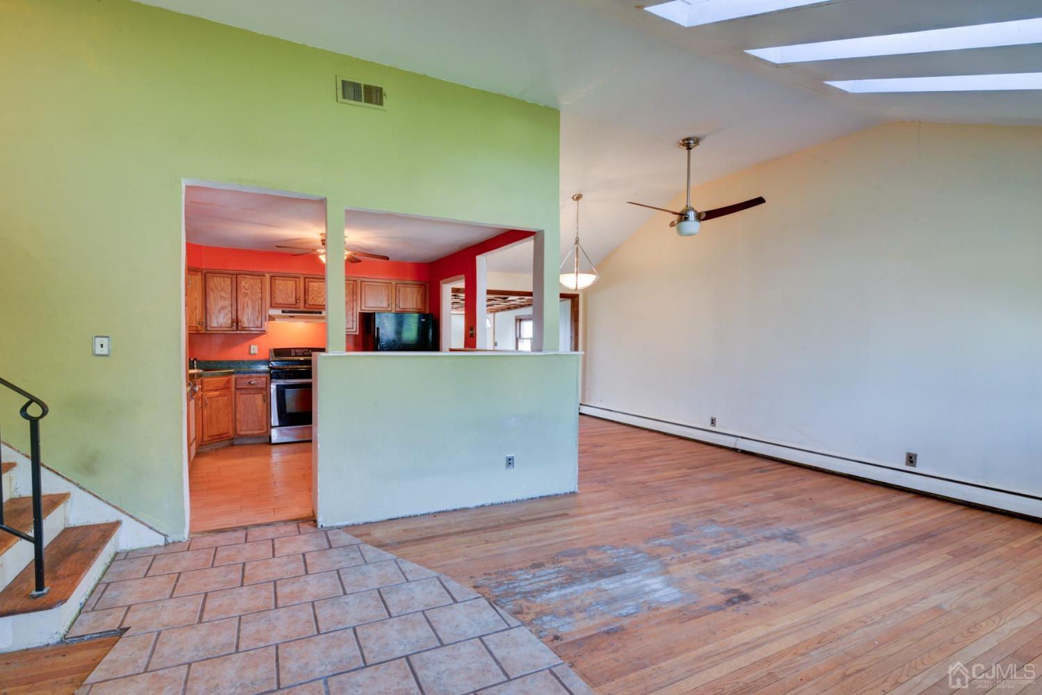 537 Ford Avenue Fords, NJ 08863 - Photo 3 of 31 an empty room with wooden floor and way to kitchen