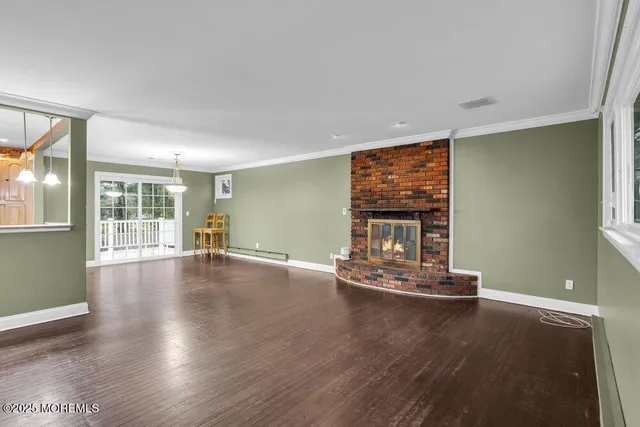 a view of a livingroom with wooden floor and furniture