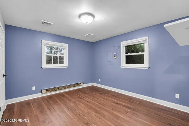 a view of empty room with wooden floor