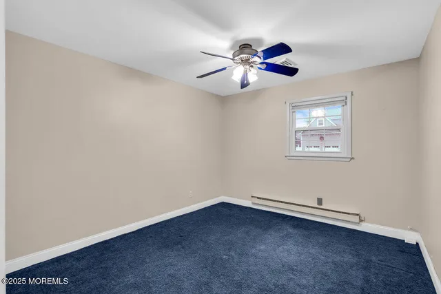 an empty room with a window and a ceiling fan