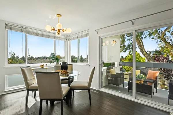 a dining room with furniture a chandelier and wooden floor
