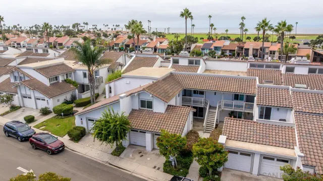 an aerial view of multiple houses with a yard