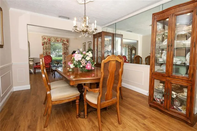 a view of a dining room with furniture a chandelier and wooden floor