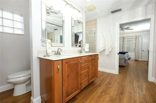 a bathroom with a sink a toilet and a large mirror