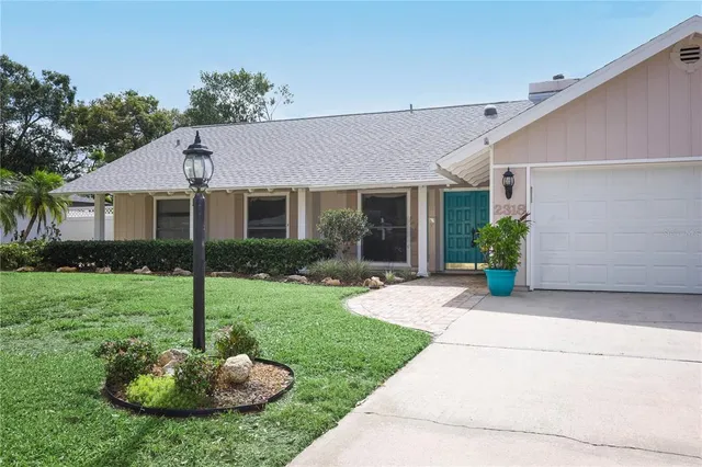 a front view of a house with a yard and a fountain