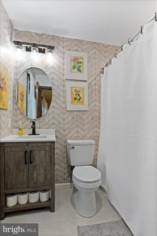a bathroom with a toilet sink and mirror