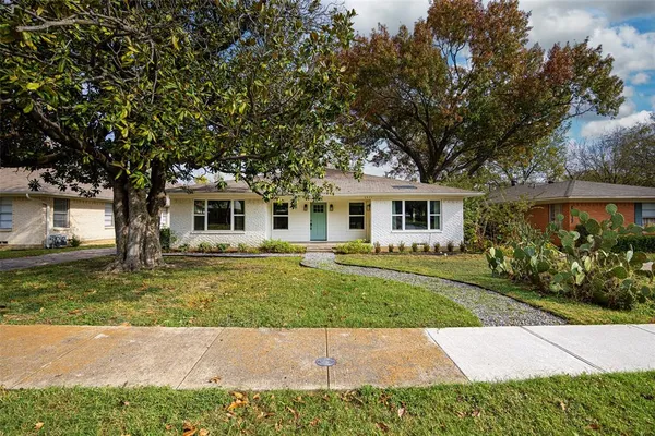 a front view of a house with a garden