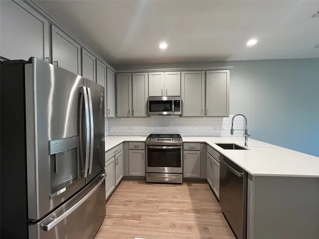 a kitchen with a sink stainless steel appliances and cabinets