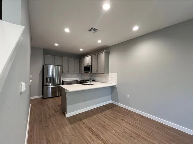 a kitchen with kitchen island a stove a sink and a refrigerator