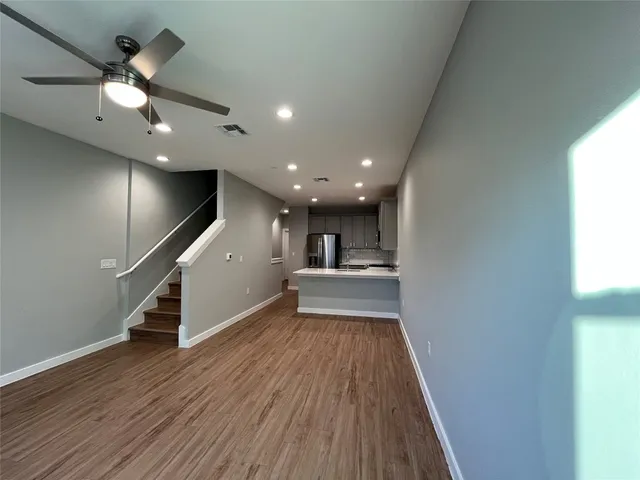 a view of a hallway with wooden floor and staircase