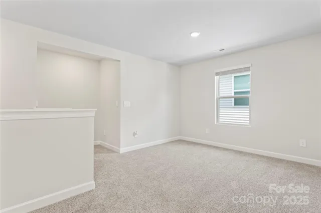 a bed sitting in a spacious bedroom next to a window