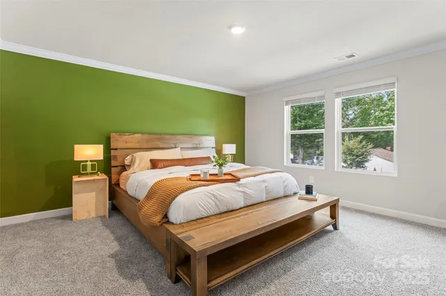 a bed sitting in a spacious bedroom next to a window