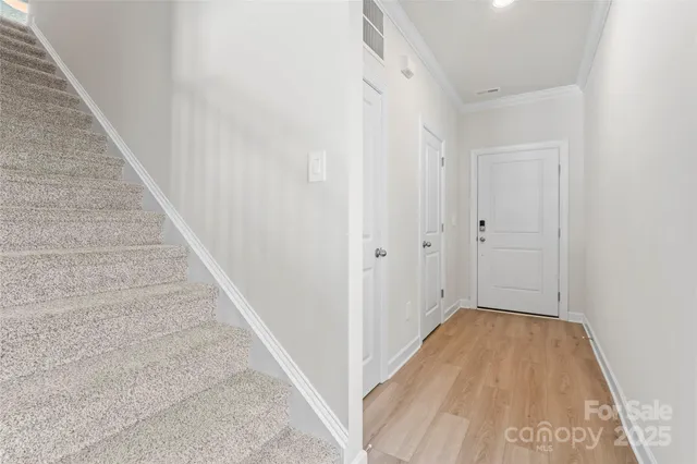 a view of a hallway with wooden floor and staircase