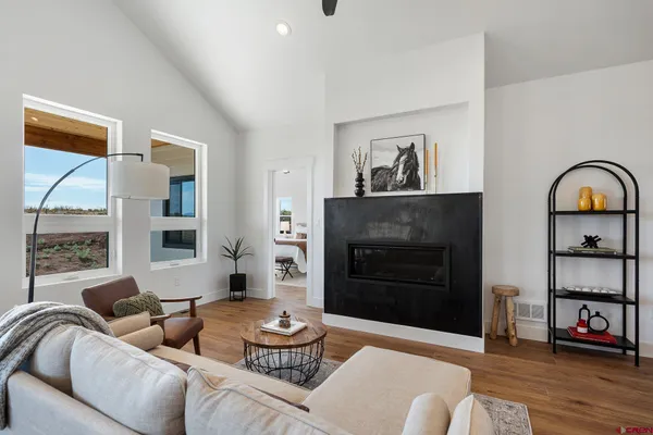 a living room with furniture a flat screen tv and a large window