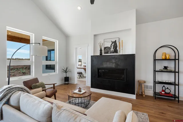 a living room with furniture a flat screen tv and a large window