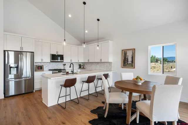 a spacious bedroom that has a bed and a chandelier