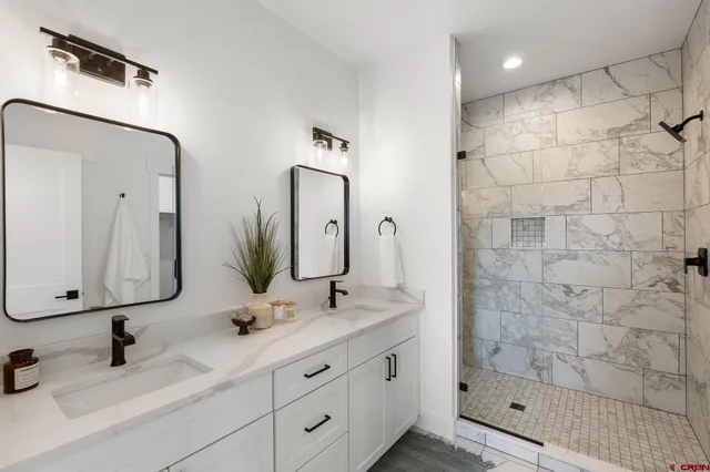 a bathroom with double vanity sinks and a mirror