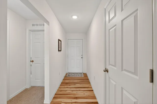 a view of a hallway with wooden floor and staircase