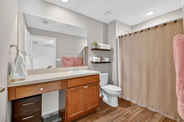 a bathroom with a granite countertop sink toilet and a mirror