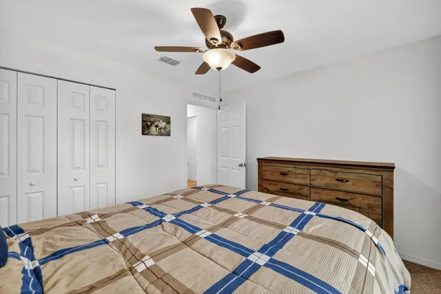 a bedroom with a bed and a ceiling fan