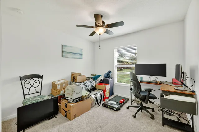 a workspace with furniture and ceiling fan